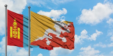 Mongolia and Bhutan flag waving in the wind against white cloudy blue sky together. Diplomacy concept, international relations.