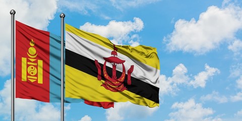 Mongolia and Brunei flag waving in the wind against white cloudy blue sky together. Diplomacy concept, international relations.