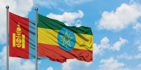 Mongolia and Ethiopia flag waving in the wind against white cloudy blue sky together. Diplomacy concept, international relations.