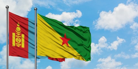 Mongolia and French Guiana flag waving in the wind against white cloudy blue sky together. Diplomacy concept, international relations.