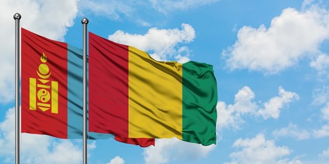 Mongolia and Guinea flag waving in the wind against white cloudy blue sky together. Diplomacy concept, international relations.