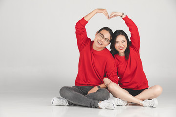 Young asian groom and bride posing and smiling in studio for pre-wedding shot.