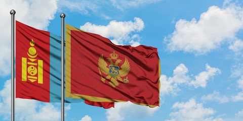 Mongolia and Montenegro flag waving in the wind against white cloudy blue sky together. Diplomacy concept, international relations.
