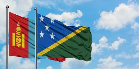 Mongolia and Solomon Islands flag waving in the wind against white cloudy blue sky together. Diplomacy concept, international relations.