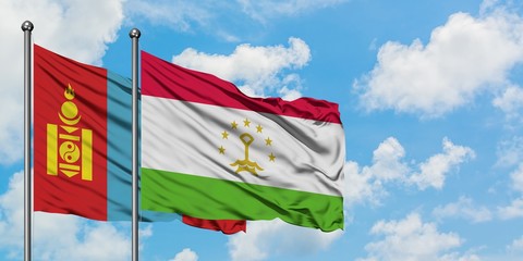 Mongolia and Tajikistan flag waving in the wind against white cloudy blue sky together. Diplomacy concept, international relations.