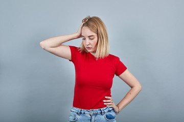 Portrait of preoccupied pensive young woman in vivid casual clothes looking aside, putting hand on...