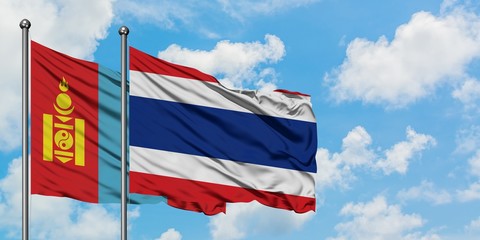 Mongolia and Thailand flag waving in the wind against white cloudy blue sky together. Diplomacy concept, international relations.