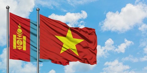 Mongolia and Vietnam flag waving in the wind against white cloudy blue sky together. Diplomacy concept, international relations.