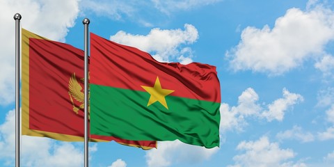 Montenegro and Burkina Faso flag waving in the wind against white cloudy blue sky together. Diplomacy concept, international relations.