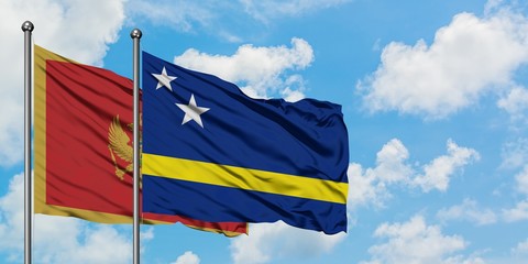 Montenegro and Curacao flag waving in the wind against white cloudy blue sky together. Diplomacy concept, international relations.