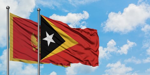 Montenegro and East Timor flag waving in the wind against white cloudy blue sky together. Diplomacy concept, international relations.