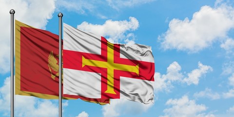 Montenegro and Guernsey flag waving in the wind against white cloudy blue sky together. Diplomacy concept, international relations.
