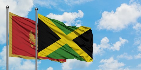 Montenegro and Jamaica flag waving in the wind against white cloudy blue sky together. Diplomacy concept, international relations.