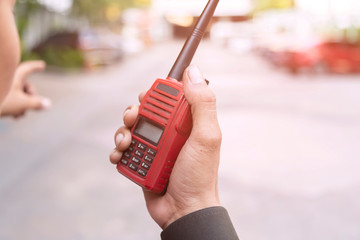 Security guard uses radio communication for facilitate traffic. Traffic Officers use walkie talkie to maintain order in the parking lot in Thailand.