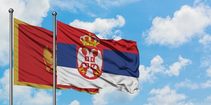 Montenegro and Serbia flag waving in the wind against white cloudy blue sky together. Diplomacy concept, international relations. - Powered by Adobe