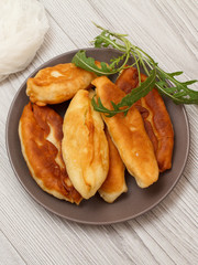 Plate with fried pies on wooden boards