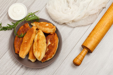 Plate with fried pies on wooden boards