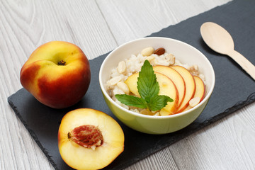 Sorghum salad with nuts and fresh peach on stone board.