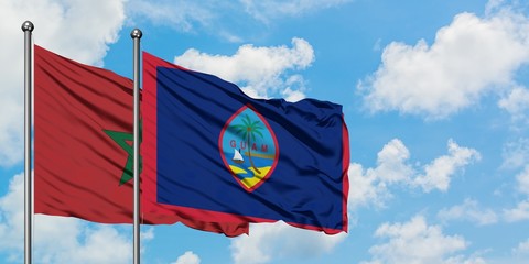 Morocco and Guam flag waving in the wind against white cloudy blue sky together. Diplomacy concept, international relations.