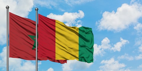Morocco and Guinea flag waving in the wind against white cloudy blue sky together. Diplomacy concept, international relations.