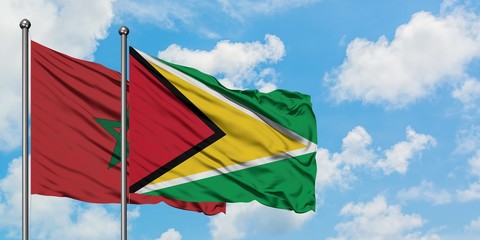 Morocco and Guyana flag waving in the wind against white cloudy blue sky together. Diplomacy concept, international relations.