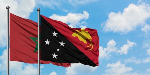 Morocco and Papua New Guinea flag waving in the wind against white cloudy blue sky together. Diplomacy concept, international relations.