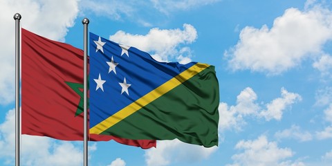 Morocco and Solomon Islands flag waving in the wind against white cloudy blue sky together. Diplomacy concept, international relations.