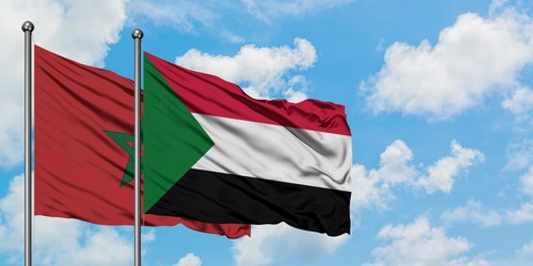 Morocco and Sudan flag waving in the wind against white cloudy blue sky together. Diplomacy concept, international relations.