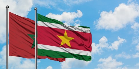 Morocco and Suriname flag waving in the wind against white cloudy blue sky together. Diplomacy concept, international relations.