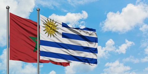 Morocco and Uruguay flag waving in the wind against white cloudy blue sky together. Diplomacy concept, international relations.