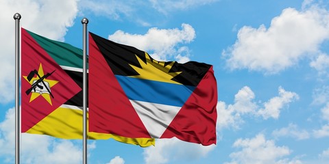 Mozambique and Antigua and Barbuda flag waving in the wind against white cloudy blue sky together. Diplomacy concept, international relations.