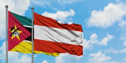 Mozambique and Austria flag waving in the wind against white cloudy blue sky together. Diplomacy concept, international relations.