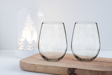Christmas wine glasses Mockup - feminine style, two stemless glasses on a wooden board infront of a...