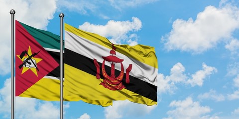 Mozambique and Brunei flag waving in the wind against white cloudy blue sky together. Diplomacy concept, international relations.
