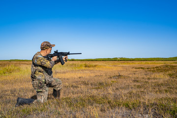 Fototapeta premium man with a gun standing in the field