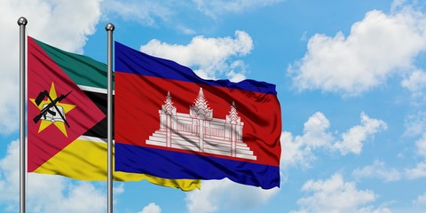 Mozambique and Cambodia flag waving in the wind against white cloudy blue sky together. Diplomacy...