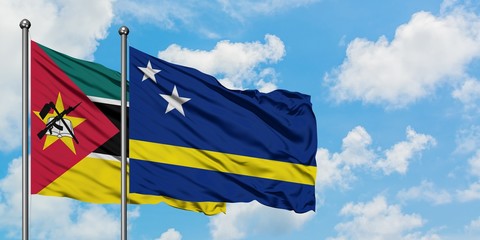 Mozambique and Curacao flag waving in the wind against white cloudy blue sky together. Diplomacy concept, international relations.