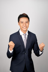 Happy businessman celebrating his success over white background. Looking at camera