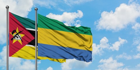 Mozambique and Gabon flag waving in the wind against white cloudy blue sky together. Diplomacy concept, international relations.