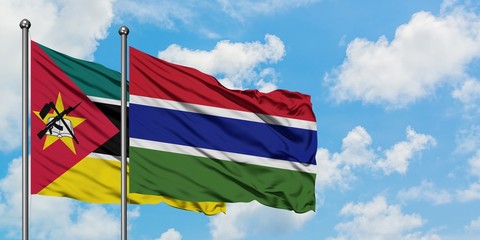 Mozambique and Gambia flag waving in the wind against white cloudy blue sky together. Diplomacy concept, international relations.