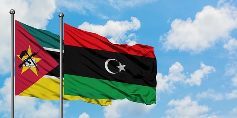 Mozambique and Libya flag waving in the wind against white cloudy blue sky together. Diplomacy concept, international relations.