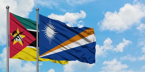 Mozambique and Marshall Islands flag waving in the wind against white cloudy blue sky together. Diplomacy concept, international relations.