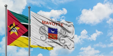 Mozambique and Mayotte flag waving in the wind against white cloudy blue sky together. Diplomacy concept, international relations.