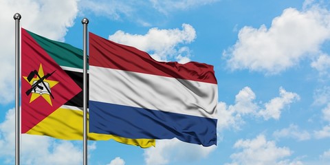 Mozambique and Netherlands flag waving in the wind against white cloudy blue sky together. Diplomacy concept, international relations.