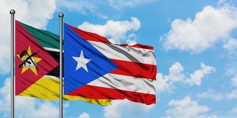 Mozambique and Puerto Rico flag waving in the wind against white cloudy blue sky together. Diplomacy concept, international relations.