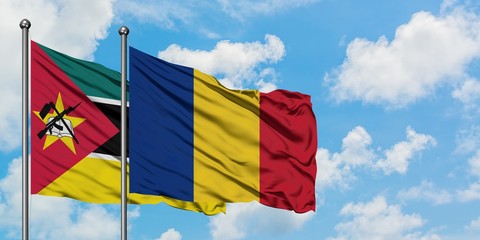 Mozambique and Romania flag waving in the wind against white cloudy blue sky together. Diplomacy concept, international relations.