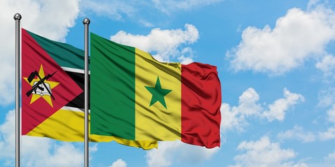 Mozambique and Senegal flag waving in the wind against white cloudy blue sky together. Diplomacy concept, international relations.