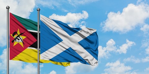 Mozambique and Scotland flag waving in the wind against white cloudy blue sky together. Diplomacy concept, international relations.