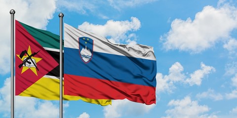 Mozambique and Slovenia flag waving in the wind against white cloudy blue sky together. Diplomacy concept, international relations.