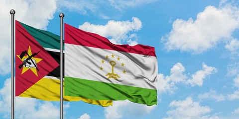 Mozambique and Tajikistan flag waving in the wind against white cloudy blue sky together. Diplomacy concept, international relations.